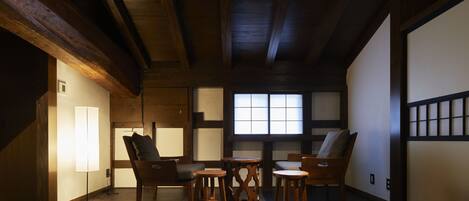 A traditional Japanese-style room with tatami flooring, wooden furniture, and a sliding door.
