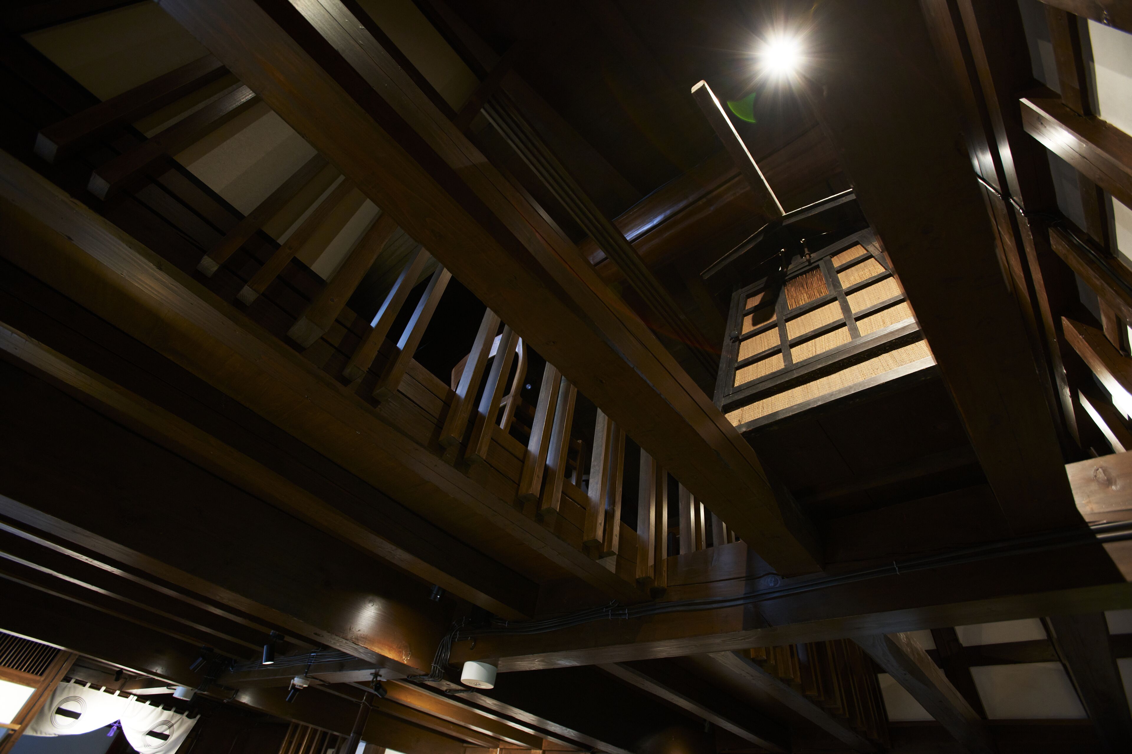 A high ceiling with exposed wooden beams and a skylight.