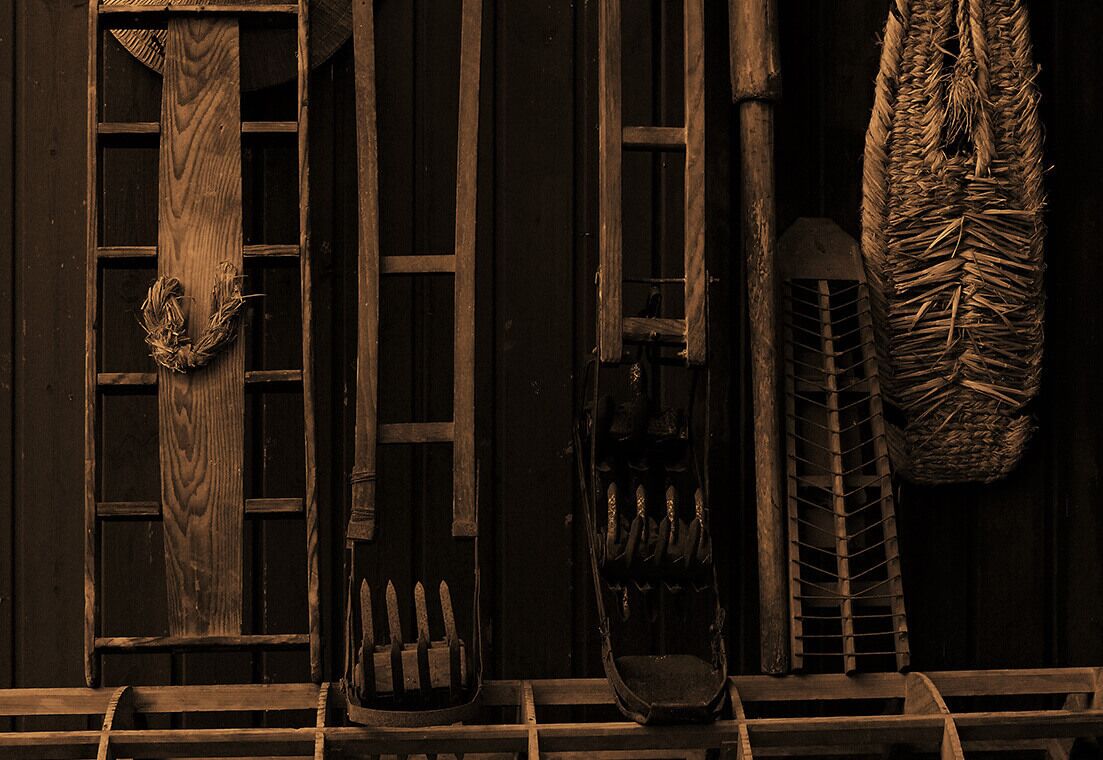 A rustic wooden door with a wreath, a metal gate, and a woven basket.