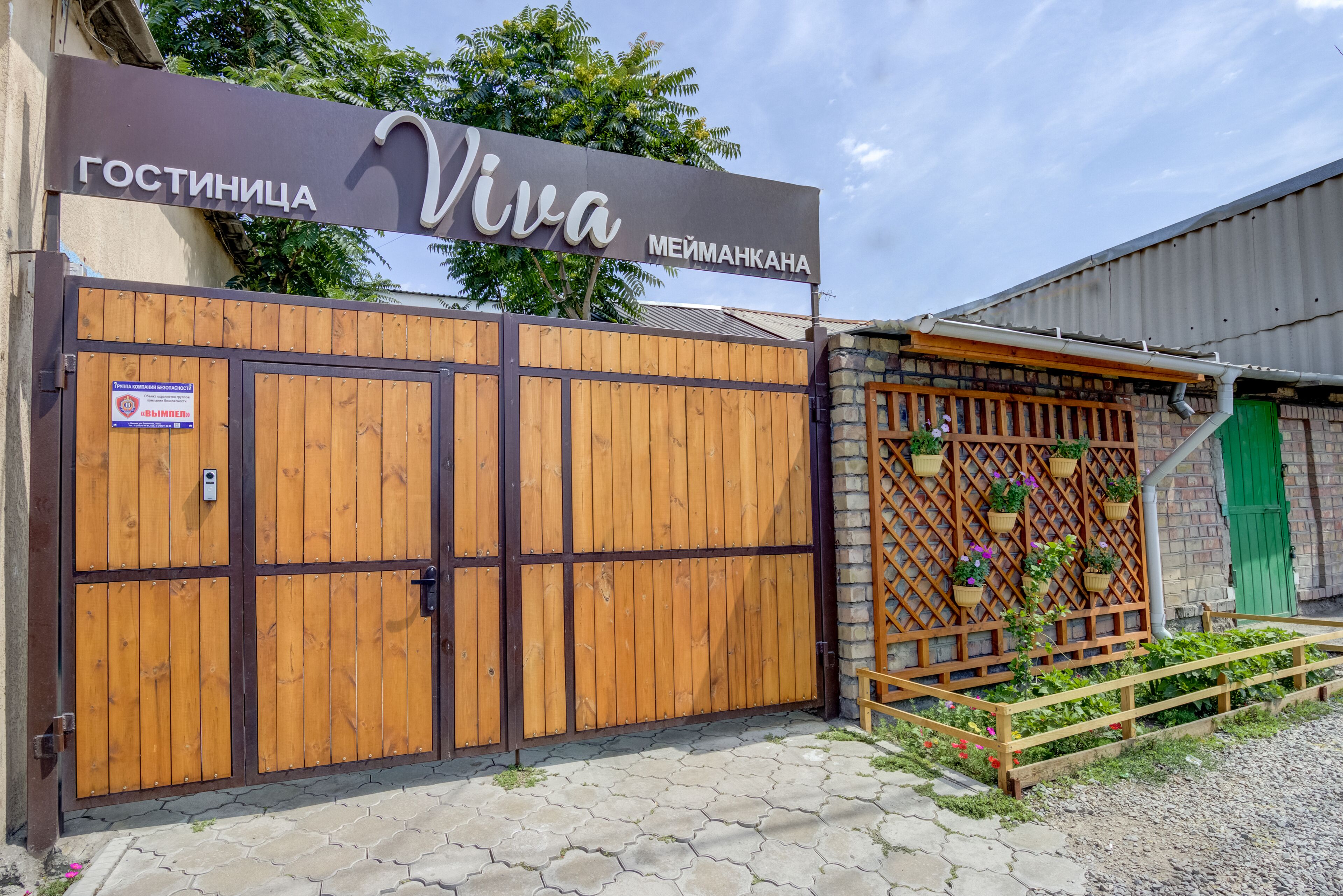 Ein verschlossenes Tor mit Holzpfeilung und einem Schild mit der Aufschrift 'Viva'.
