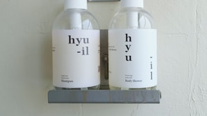 Two bottles of hyu-il shampoo and body shower on a white wall. - See U Apartment (Tainan)