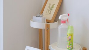 A white shelf with a framed picture and a spray bottle. - See U Apartment (Tainan)