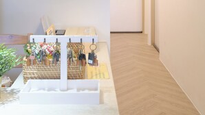 A hallway with a white door marked 1205, a white pendant light, and a wall-mounted key rack. - See U Apartment (Tainan)