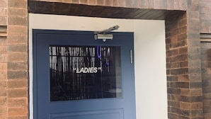A blue door with a window displaying the word "LADIES". - Capsule inn Bali (Legian)