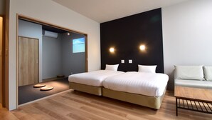 A modern bedroom with a large bed, a sofa, and a wooden floor. - Rakuten STAY MOTEL Kujukurihama Katakai (Kujukuri)