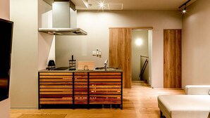 A compact living space with a kitchenette, a wooden cabinet, a sofa, and a staircase leading to another room. - Rakuten STAY MOTEL Kujukurihama Katakai (Kujukuri)