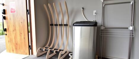 Una habitación con puerta de madera, dispensador de agua y un estante metálico.