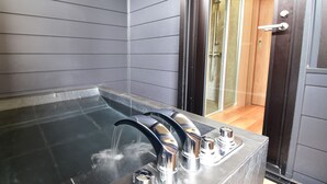 A modern bathroom with a glass-enclosed hot tub, a shower area, and a wooden door. - Rakuten STAY MOTEL Kujukurihama Katakai (Kujukuri)