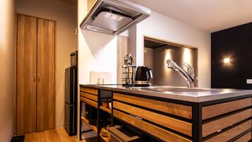 A modern kitchen with a stainless steel sink, wooden cabinets, and a built-in oven.