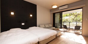A modern bedroom with a large bed, a sofa, and a balcony with chairs. - Rakuten Stay Motel Nikko Kinugawa (Nikko)