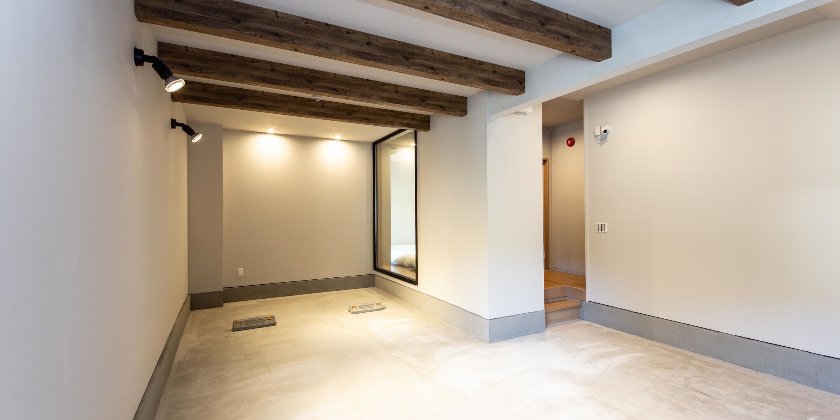 Un couloir moderne avec des poutres en bois apparentes, un éclairage encastré et un design épuré et minimaliste.