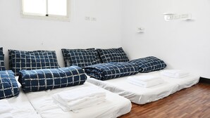 A room with three beds, each with white and blue patterned bedding. - Tumbler Travel (Jinning)