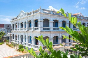 A multi-story building with a classical architectural style, featuring arched windows and balconies. - Tumbler Travel (Jinning)