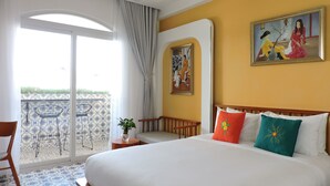 A hotel room with a large bed, a balcony with patterned floor tiles, and a painting on the wall. - Chez Mimosa Local Homestay (Ho Chi Minh City)