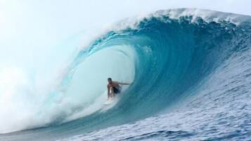 Een surfer die een hoge golf betrapt.