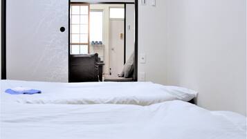 A hotel room with a bed, a chair, and a desk with a computer.