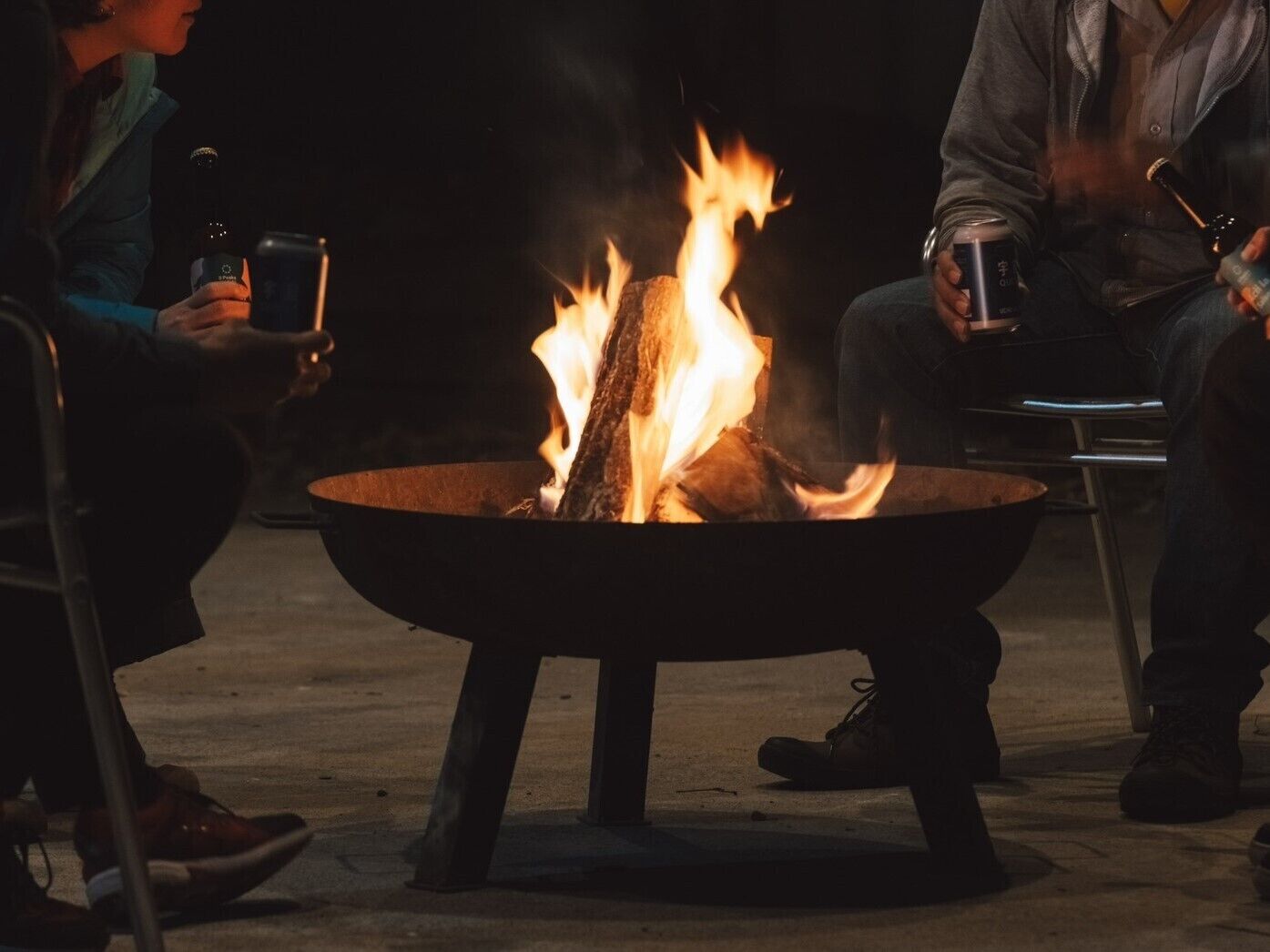 A group of people seated around a central fire pit.