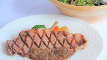 A plate with grilled meat, vegetables, and a side salad.
