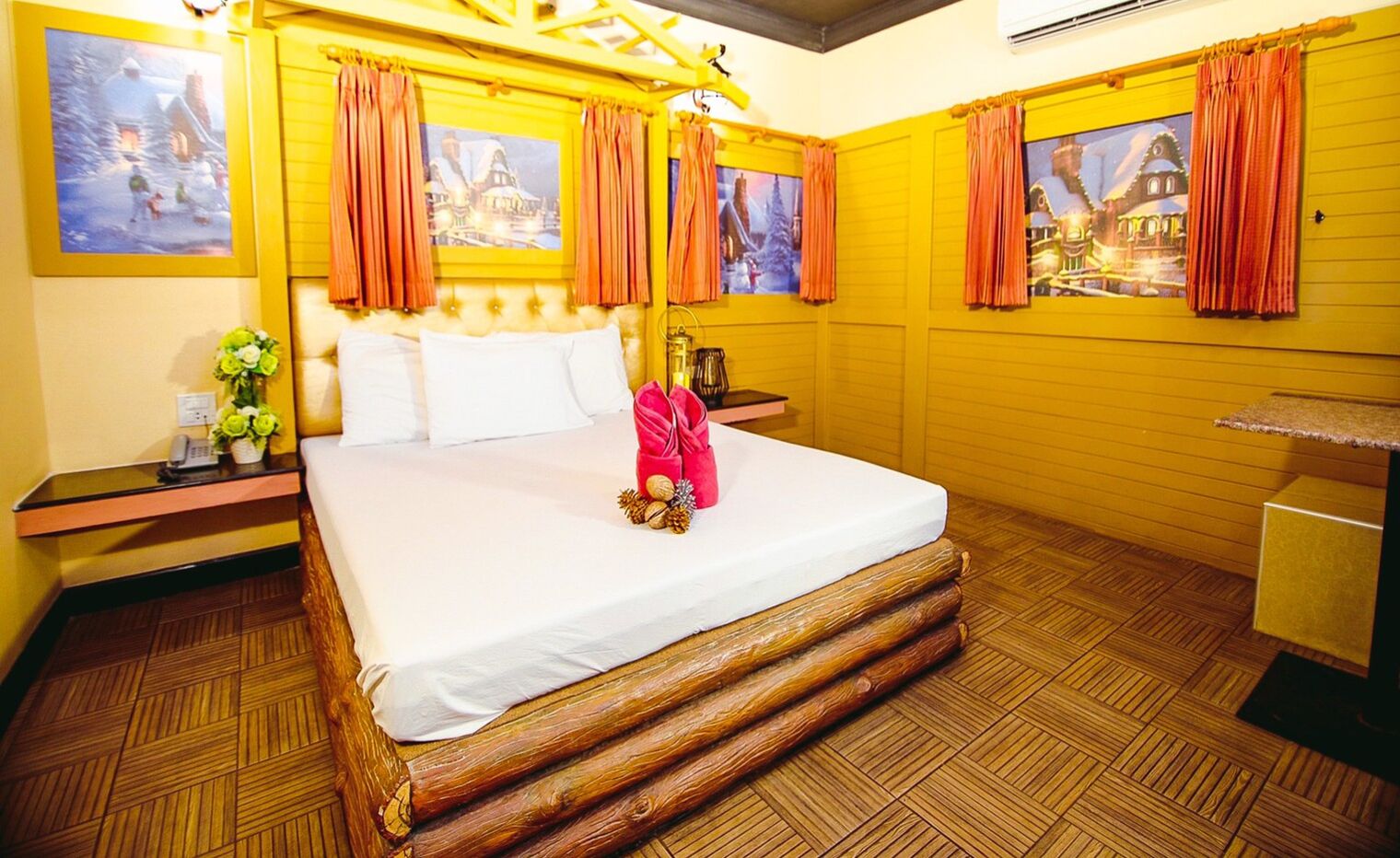 Quarto de hotel com uma cama grande, cabeceira de madeira e um arranhador para gatos.
