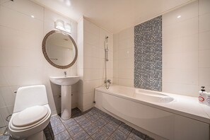 A bathroom with a toilet, sink, and bathtub.