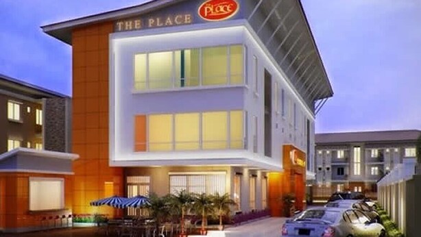 A modern hotel named "The Place" with a prominent sign, a covered outdoor seating area, and a parking lot. - Demiral Hotel at The Place Lekki (Lekki)