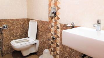 A bathroom with a toilet, a sink, and a shower.