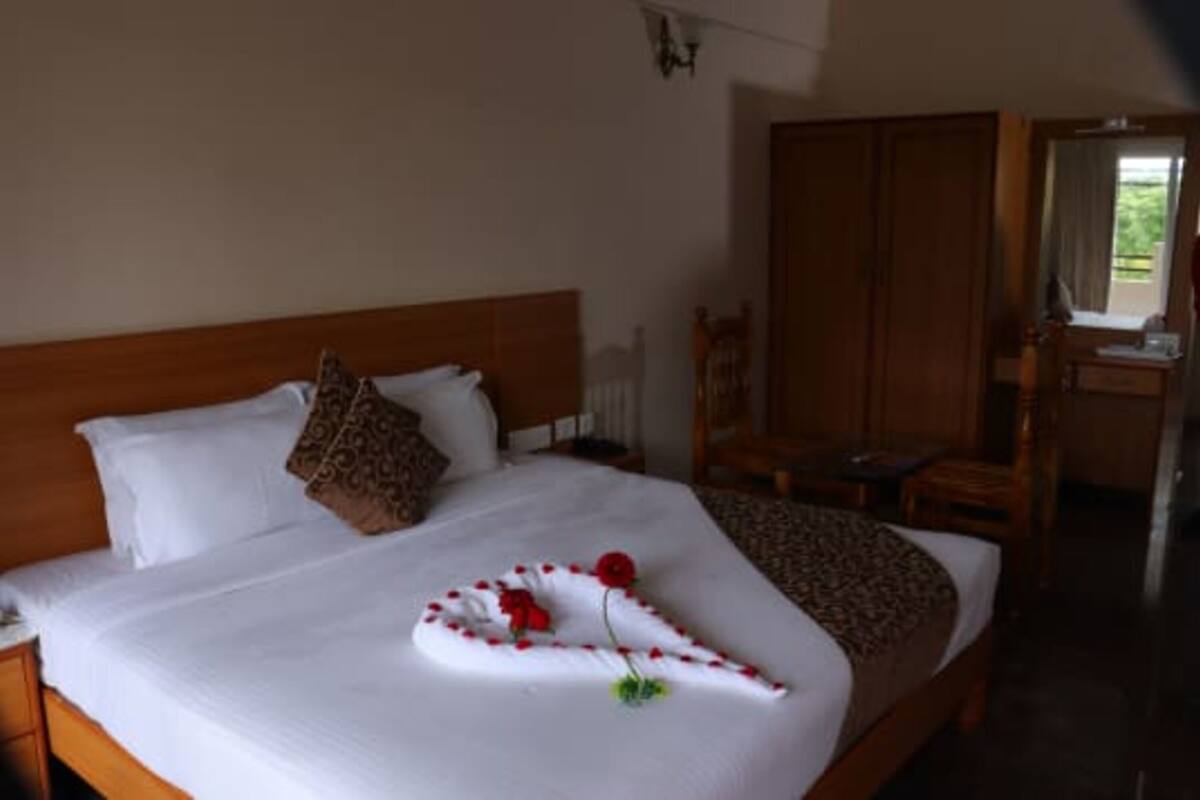 A neatly made bed with a decorative arrangement of flowers and a towel.