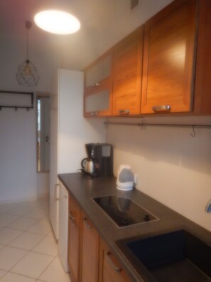 Enjoy cooking in this well-equipped kitchen with a sink, refrigerator, and coffee maker.