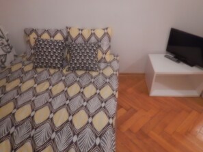 Relax in this stylish bedroom with a patterned bedspread and a flat-screen TV on a side table.