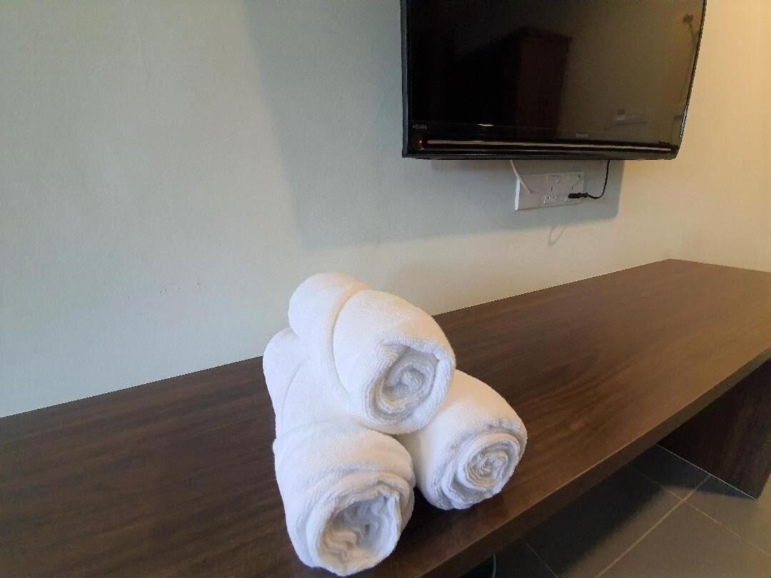 A wooden bench with rolled white towels placed on it.