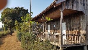 A rustic wooden building with a porch, a number 33 sign, and a dirt path leading to it. - Dream Resort Farm (Lomsaktay)