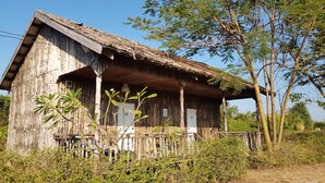 A rustic wooden building with a porch, surrounded by greenery and trees. - Dream Resort Farm (Lomsaktay)