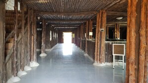 A corridor with wooden pillars, tiled floor, and a sign indicating WiFi availability. - Dream Resort Farm (Lomsaktay)