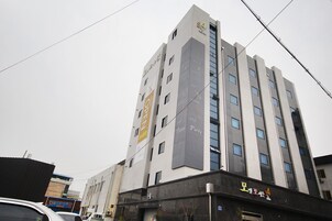 A multi-story building with a modern architectural design, featuring a prominent vertical sign with the text "Party" and a smaller sign below with the text "4".
