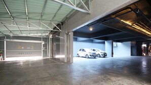 Un amplio estacionamiento techado con un coche blanco aparcado a lo lejos.