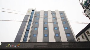 Un hotel de varios pisos con un diseño moderno, que presenta un llamativo diseño de rayas verticales y numerosas ventanas.