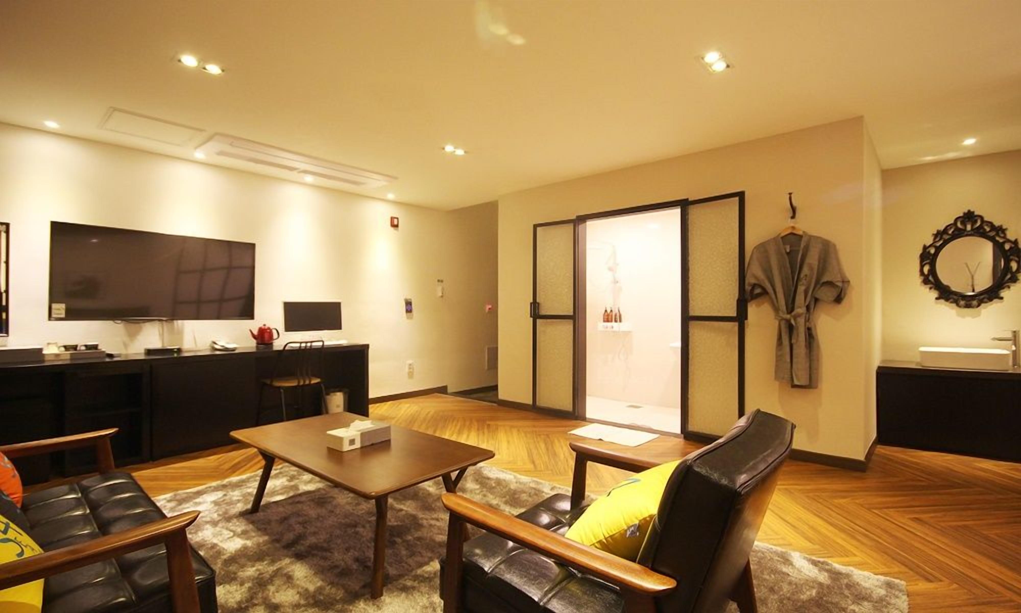 A modern living room with a sofa, a coffee table, and a TV.