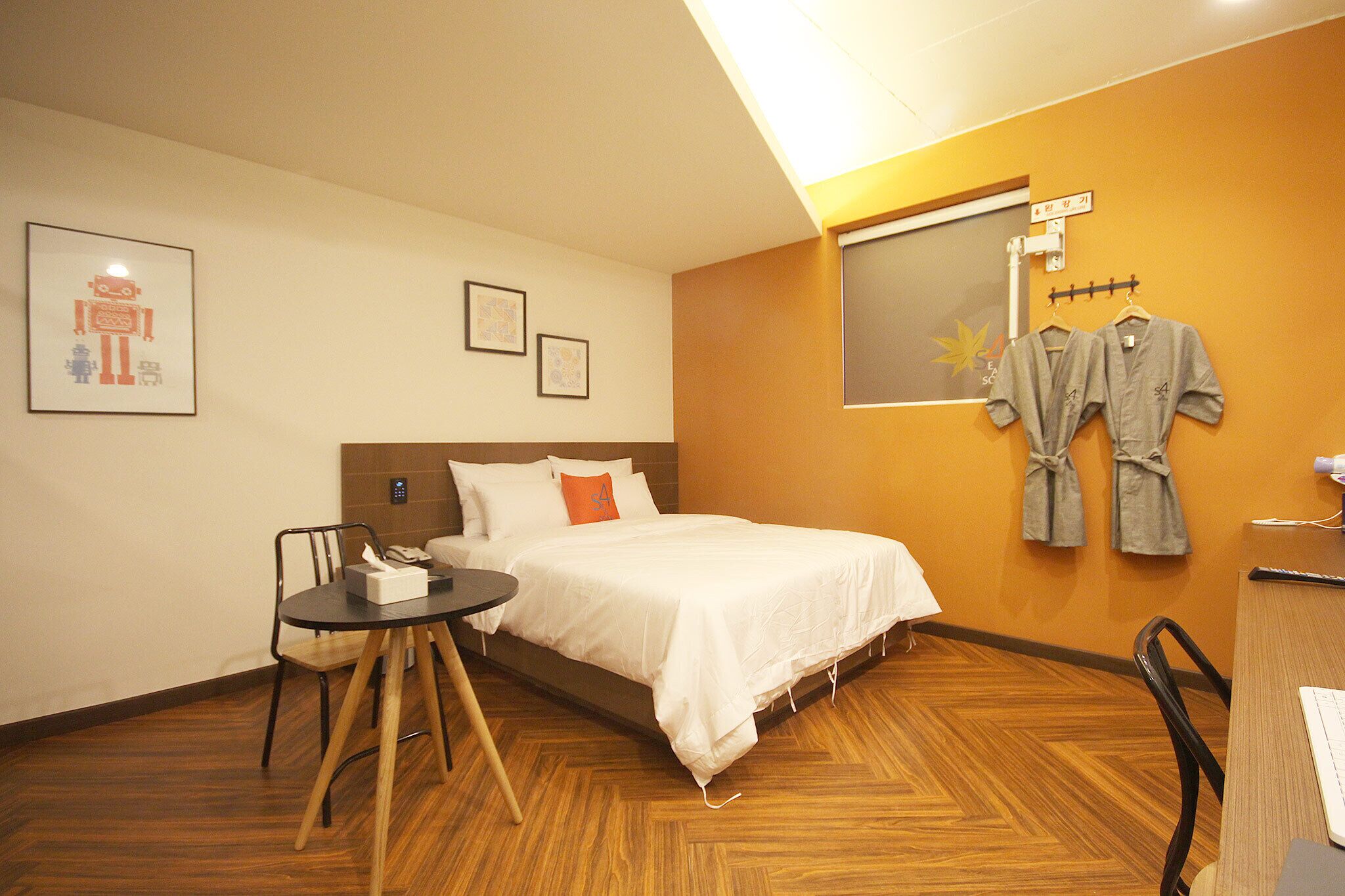 Una habitación de hotel con cama, escritorio, silla, mesa y ventana.
