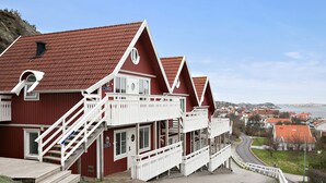 Ein rotes Gebäude mit weißen Geländern und einer Treppe, die zu einem Balkon führt.