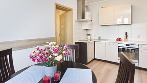 A modern kitchen with white cabinets, a built-in oven, and a coffee maker. - Victus Apartamenty - Chopin 2 (Sopot)