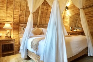 Cozy retreat with a four-poster bed, nightstands, and exposed wooden beams.