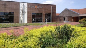 A modern building with a sign reading "Clinique." - Apartment Lee - Apartments on the old dike in the guest house (Wittmund)