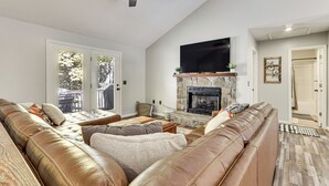 A spacious living room with a leather sofa, a stone fireplace, and a ceiling fan. - Home < 2 Mi to Mtn Greens Golf, Massanutten Ski! (Mcgaheysville)
