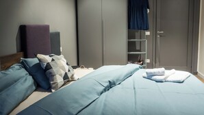 A bedroom with a bed, pillows, a wardrobe, and a hanging dress. - Le Logge 2 apartment (Parma)