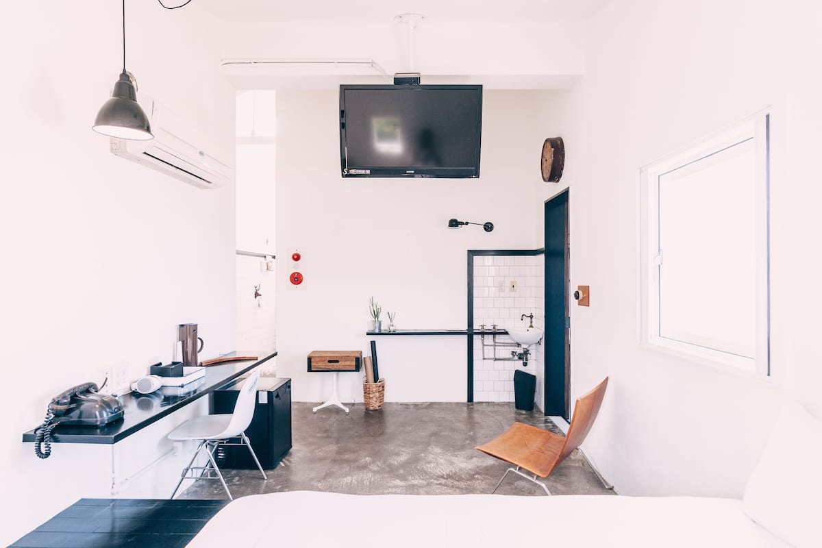 A modern, compact living space with a kitchenette, a dining area, and a seating area.