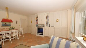 A living room with a dining area, white cabinetry, a television, and a window with a view. - House Tondernhüs, Germany (Sylt-Ost)