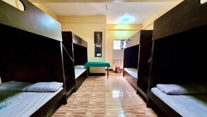 A corridor with bunk beds on either side and a central bench.