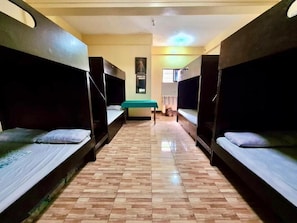 A corridor with bunk beds on either side and a central bench.