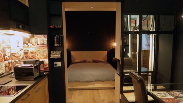 A compact bedroom with a bed, a small kitchenette, and a dining area. - Michele Guest House (Pisa)