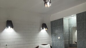 A hotel room with two beds, a nightstand with a lamp, a mirror, and a chandelier. - Baan Lanna Resort (Chonburi)